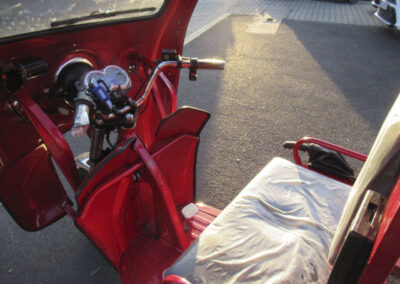 Innenraumaufnahme des roten Cargo Runner Classic Plus mit Blick auf Fahrersitz und Lenker