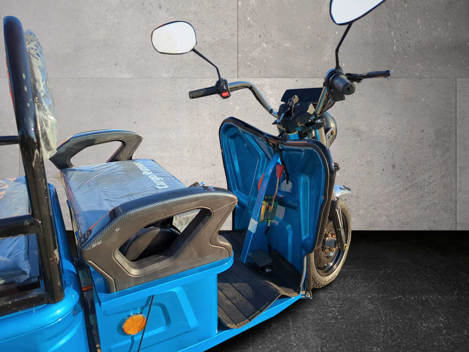 Seitliche Perspektive auf den Fahrerplatz des Cargo Runner Compact blau