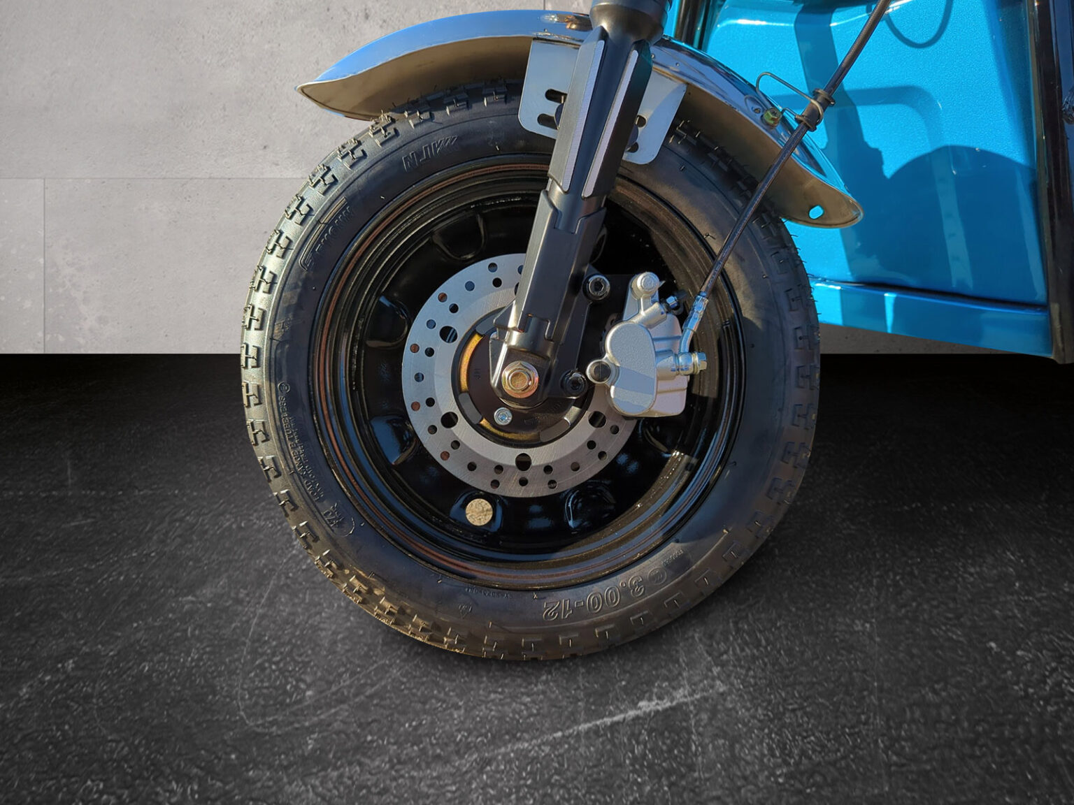 Detailaufnahme des Vorderrads mit Reifenprofil und Bremse