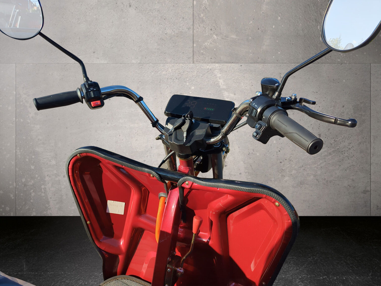 Nahaufnahme des Lenkers mit Gasgriff und Spiegel des Cargo Runner Compact