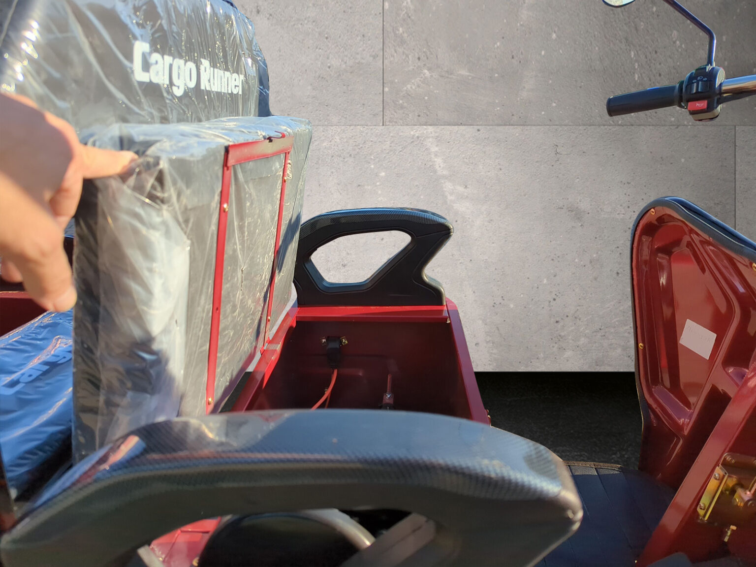 Detailaufnahme der hochgeklappten Sitzbank eines roten Cargo Runner Compact