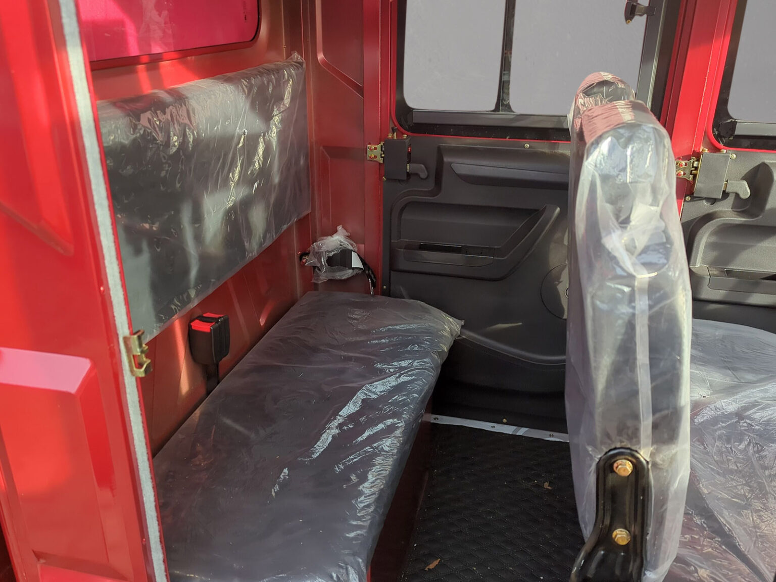 Rückbank im roten Modell mit Schutzfolie auf Sitzfläche und Lehne