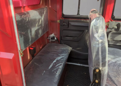 Rückbank im roten Modell mit Schutzfolie auf Sitzfläche und Lehne