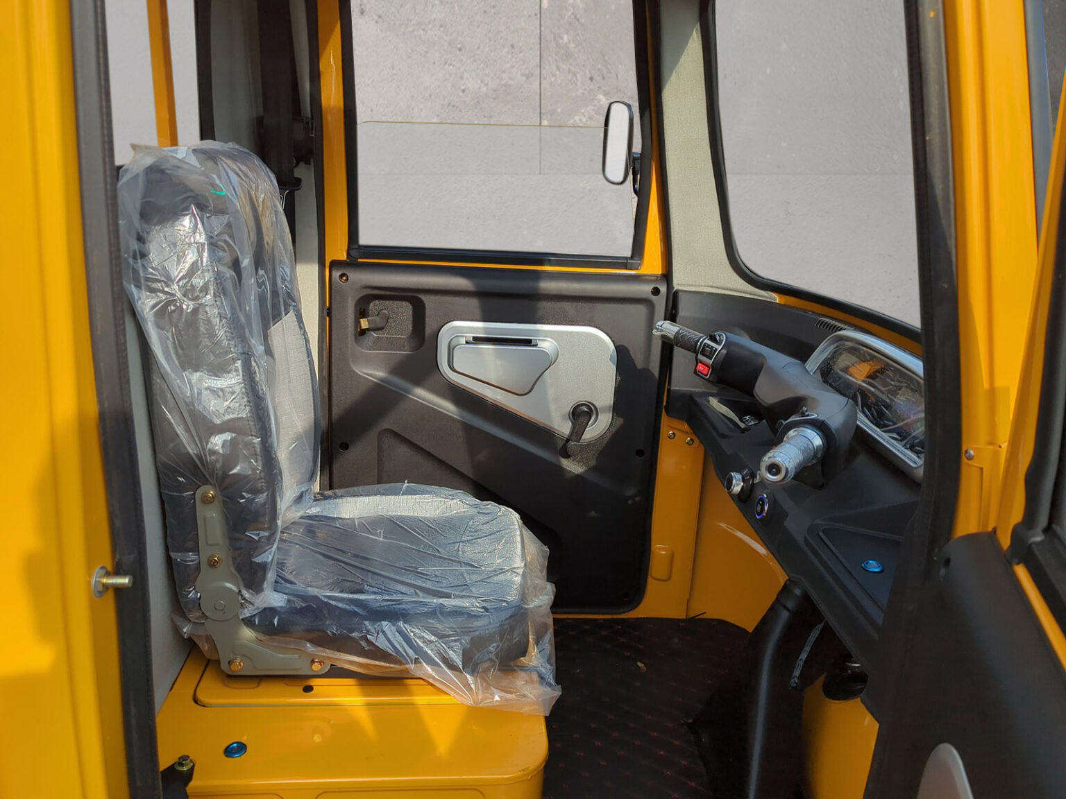 Blick auf den Fahrersitz und Türverkleidung im gelben Modell des Voltina