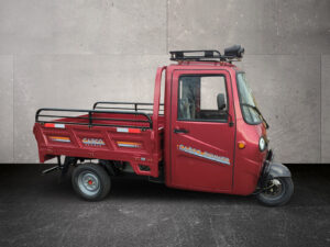 Seitenansicht Voltina in Rot mit gekippter Ladefläche, fotografiert von links