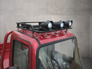 Nahaufnahme des roten Dachträgers mit Fernscheinwerfern des Cargo Runner Voltina